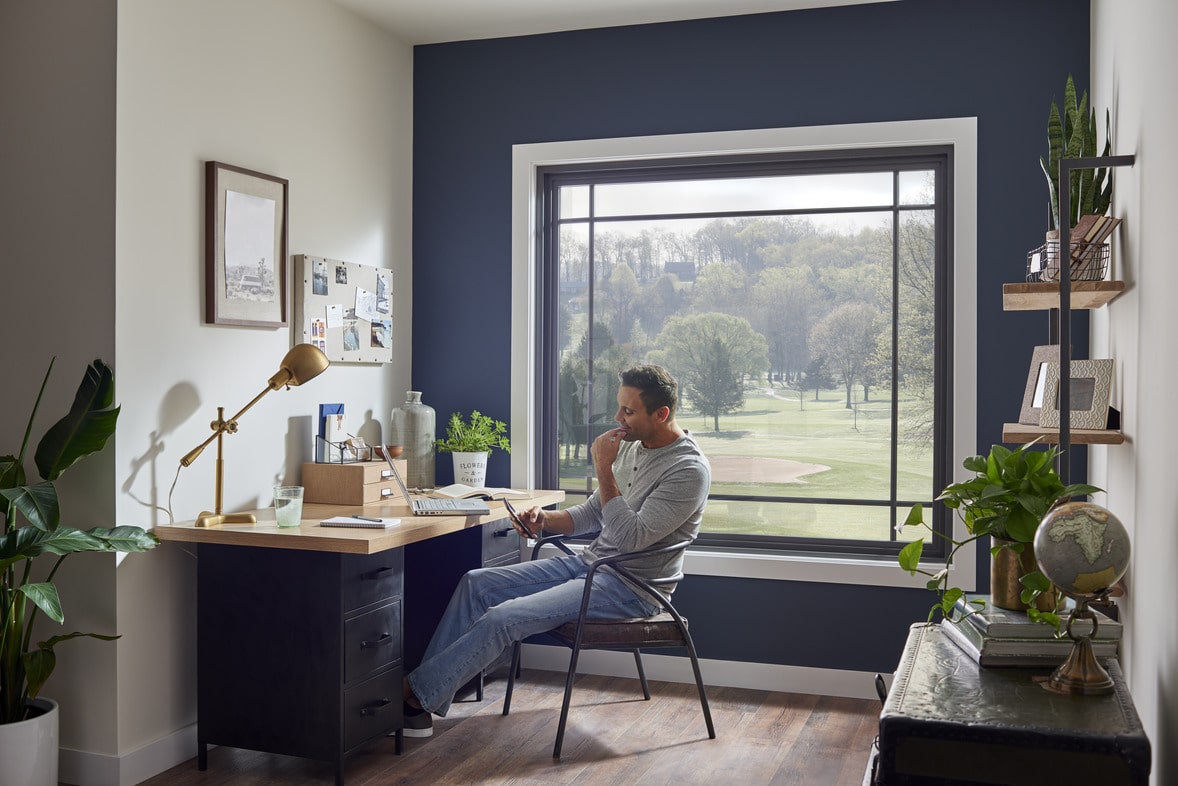 man sitting in home office with picture window